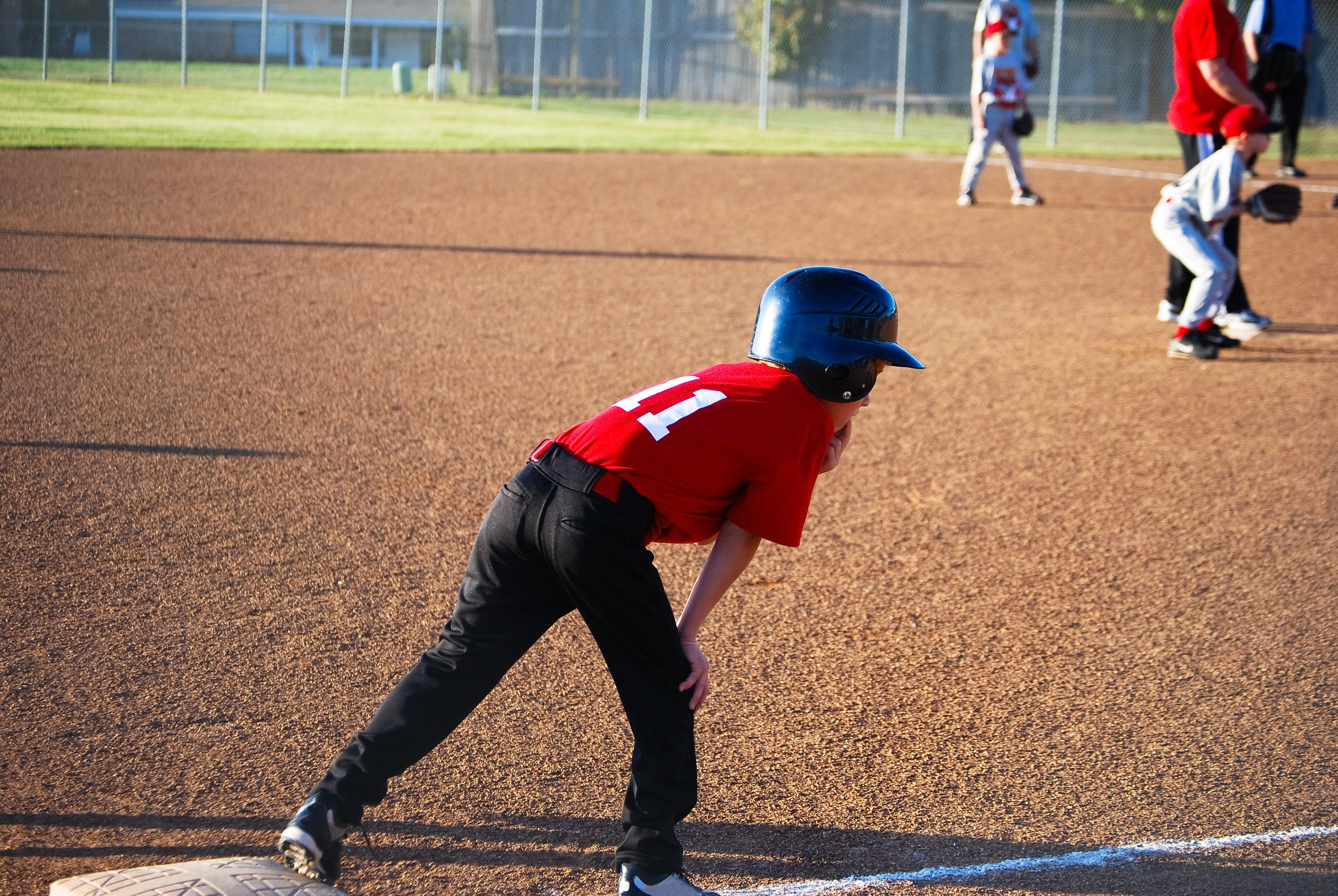 Youth baseball player on third base getting ready to run. Youth baseball player on third base getting ready to run.