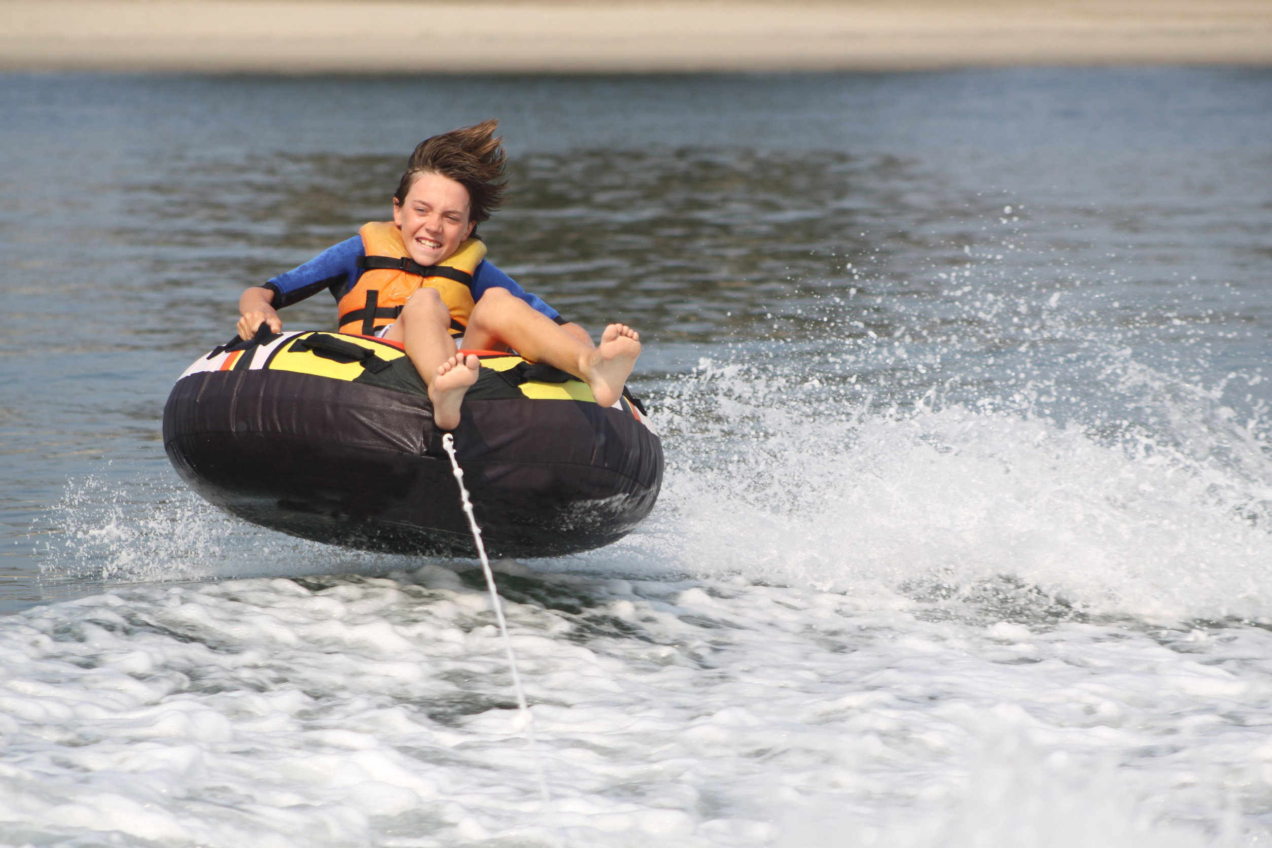 Boy on inner tube pulled by a boat Boy on inner tube pulled by a boat